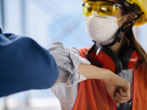 colleagues-with-safety-equipment-touching-elbow