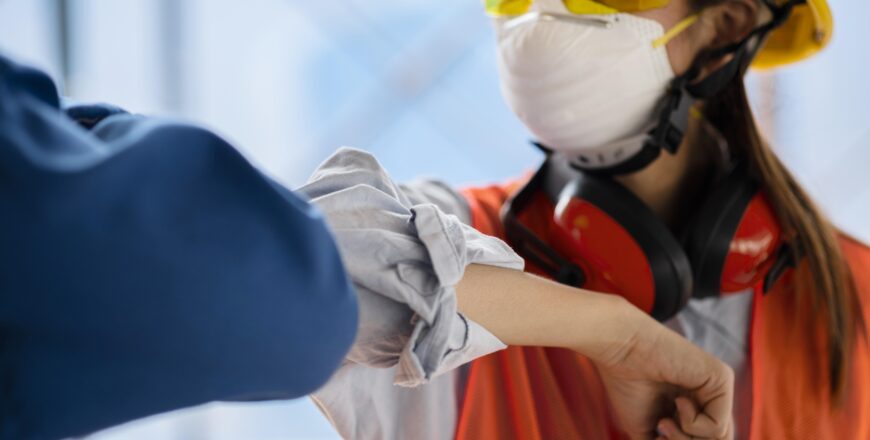 colleagues-with-safety-equipment-touching-elbow